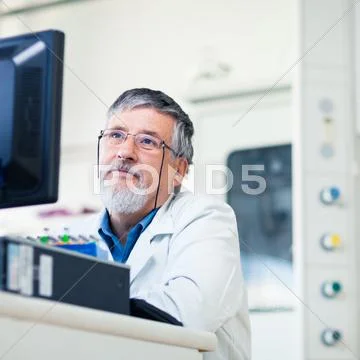 Senior researcher using a computer in the lab while working on a Stock Photos