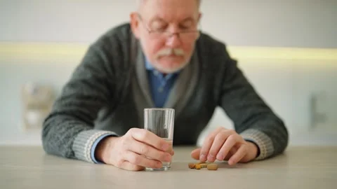 Senior responsible man drinking water taking medication pills, vitamins standing Stock Footage 240655948