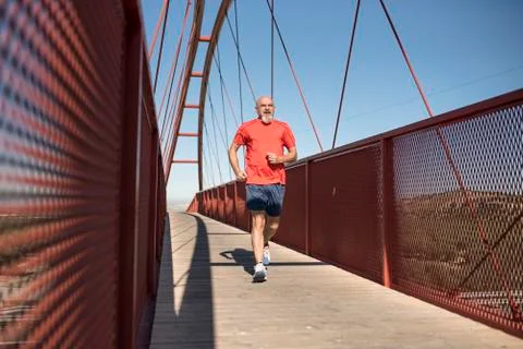 Senior runner training on a bridge Stock-Fotos