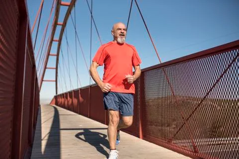 Senior runner training on a bridge Stock Photos
