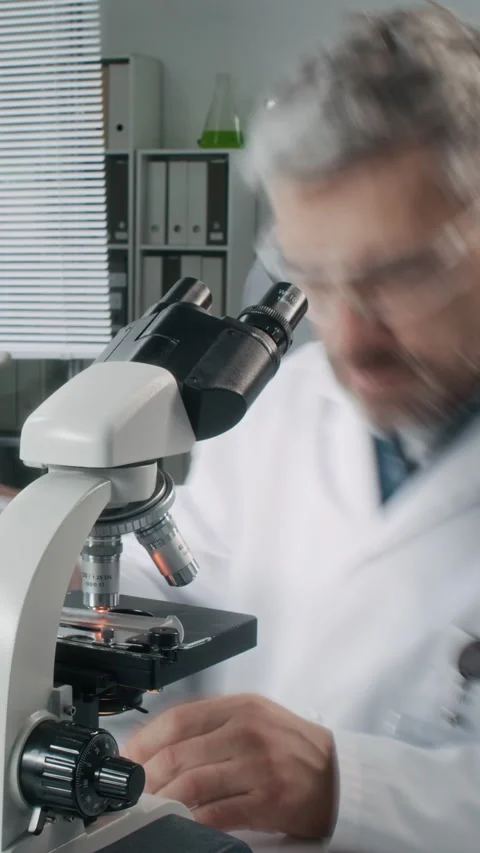 Senior Scientist Analyzing Samples Looking in Microscope Time Lapse Vertical Stock Footage 330677340