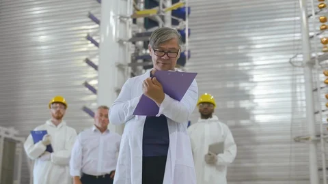 Senior scientist engineer portrait with team of workers colleagues standing Stock Footage 121099447