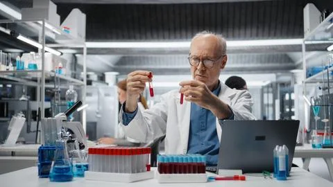 Senior scientist in lab analyzing batch of blood samples Stock Photos