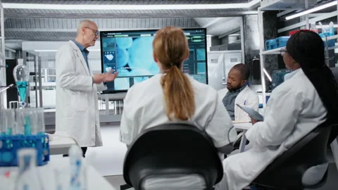 Senior scientist in lab presents innovative DNA sequencing project to colleagues Stock Footage 325819439