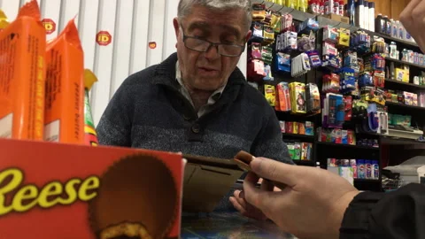 Senior Shopkeeper Processing Payment at Checkout in a Local Convenience Store Stock Footage 342341013