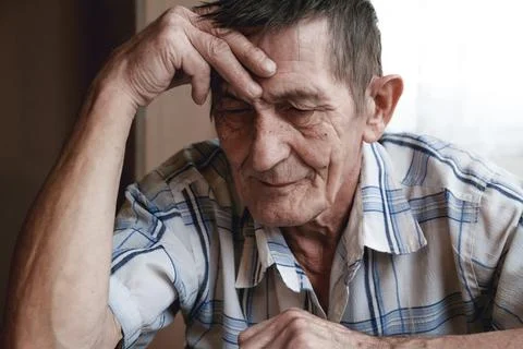 Senior sitting at the table and thinking about something or forg Foto stock