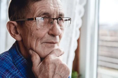 Senior standing at the window and thinking about something or fo Foto stock