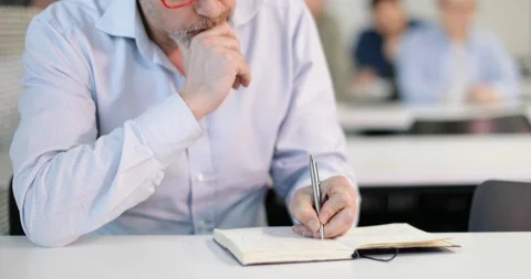 Senior student taking notes in a lecture Video stock 86508878