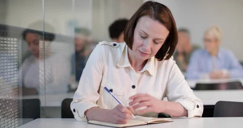 Senior student taking notes in a lecture Stock Footage 86509389
