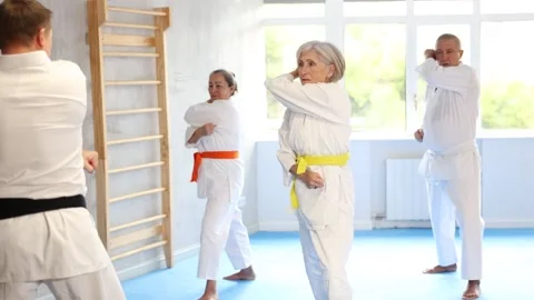 Senior students perform basic movements and repeat to hold pose, learning Video stock 321722336