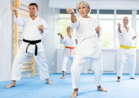 Senior students perform basic movements and repeat to hold pose, learning Foto stock