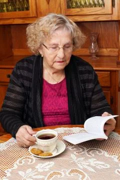 Senior with tea reading Stock Photos
