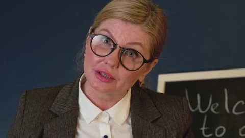 Senior teacher is explaining something from a book during a lesson near the Stock Footage 146513183