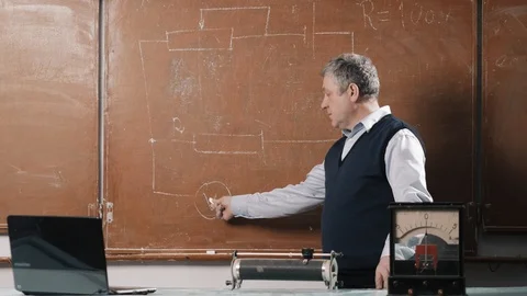Senior teacher explains lesson, talking with students and writing Stock Footage 102844169