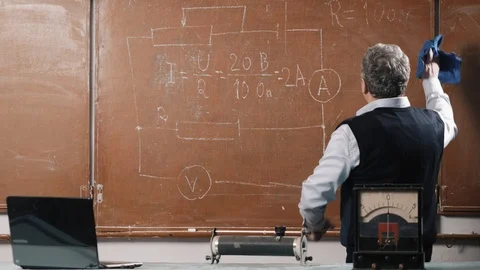 Senior teacher explains lesson, talking with students and writing Stock Footage 102850140