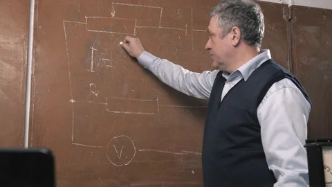 Senior teacher explains lesson, talking with students and writing Stock Footage 102881654