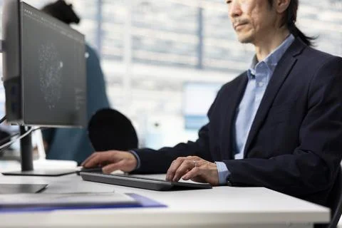 Senior technician analyzing microchip architecture layouts with AI in RD office Stock Photos