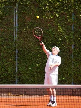 Senior tennis player about to serve the ball Stock Photos