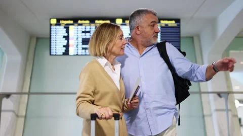 Senior tourists checking flight information at airport Stock Footage 300858958