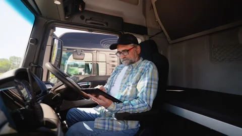 Senior trucker using truck gps navigation to transport and deliver goods to the Stock Footage 281611096