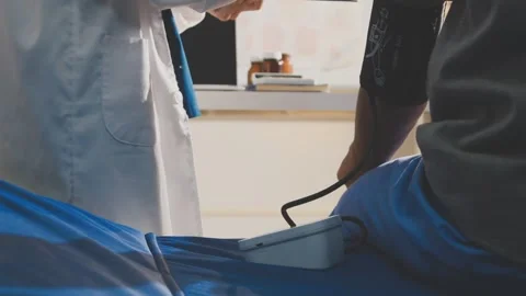 Senior using a blood pressure cuff during a telemedicine consultation via d.. Stock Footage 343707925