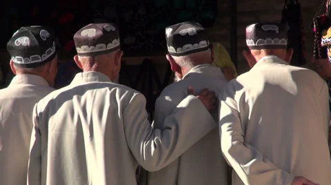Senior Uzbek men, friends, classic muslim hats, hand on shoulder, friendship Stock Footage
