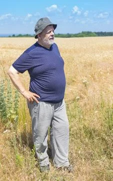 Senior wearing hat  while standing in wheat   field Stock Photos