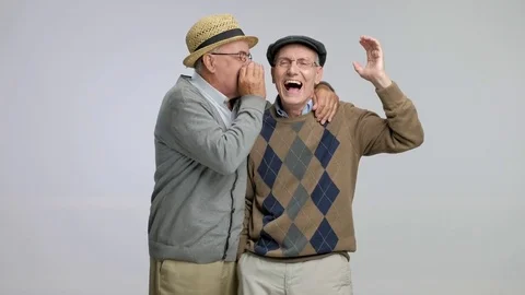 Senior whispering something funny to another senior Stock Footage 77505692