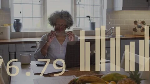 Senior woman adjusting specs while reviewing budget at laptop causing data Stock Footage 334743673