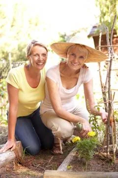 Senior Woman And Adult Daughter Relaxing In Garden Stock Photos
