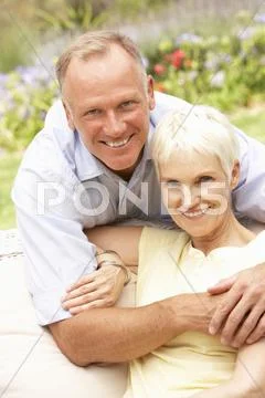 Senior Woman And Adult Son Relaxing In Garden Stock-Fotos