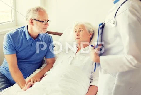 Senior woman and doctor with clipboard at hospital Stock Photos