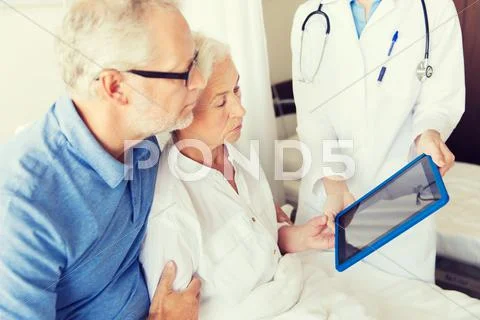 Senior woman and doctor with tablet pc at hospital Stock Photos