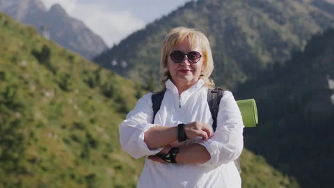 Senior woman with a backpack looking at the camera and crossing her hands on her Stock Footage 252569354