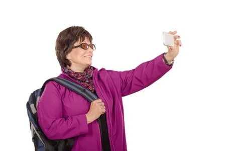 Senior woman with backpack shooting with mobile phone Stock Photos