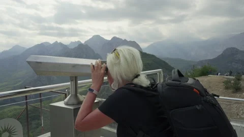 Senior woman with backpack using a viewing telescope Stock Footage 203960464