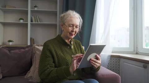 Senior woman checking emails on a tablet Stock Footage 298115151