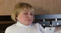 Senior woman with closed eyes sits on the sofa and listens to music HD Footage