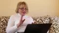 Senior woman communicates through a laptop. Woman with notebook HD Footage