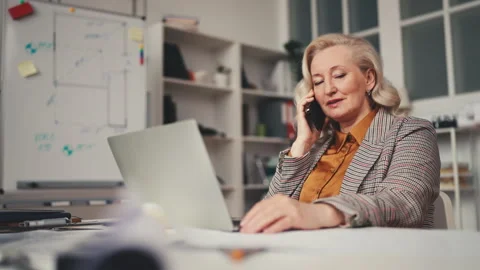 Senior woman construction developer talking on phone with clients, business Stock Footage 251858501
