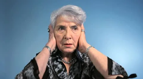 Senior woman covering her ears and looking displeased Stock Footage