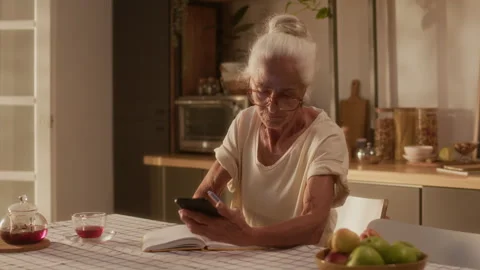 Senior Woman with Diabetes Patch Checking Glucose and Writing Down Results Stock Footage 320972900