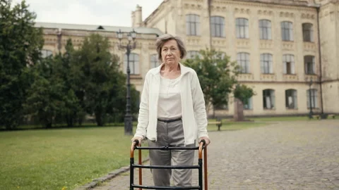 Senior woman with disability using walking frame, hip replacement surgery Stock Footage 230698237