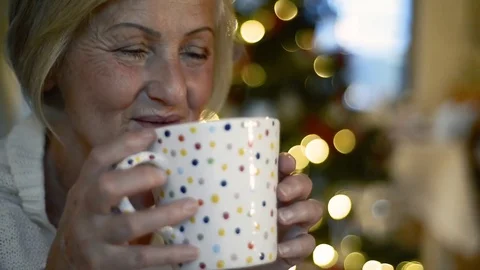 Senior woman drinking at Christmas time. Stock Footage
