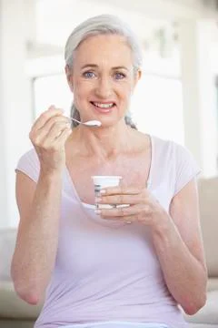 Senior Woman Eating Yogurt Stock Photos