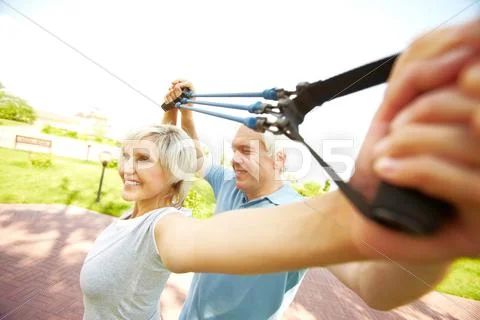 Senior woman exercising with resistance band with instructor Stock Photos