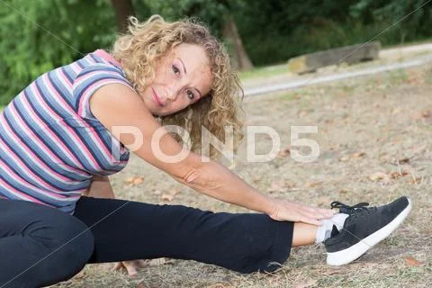 Senior woman in fitness outfit relaxing in park Stock Photos