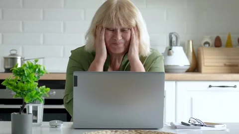 Senior woman getting frustrated while working on laptop in kitchen Video stock 316409744