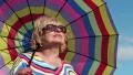 Senior woman in glasses with colorful umbrella HD Footage