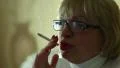 Senior woman with glasses smoking a cigarette, female smoker HD Footage
